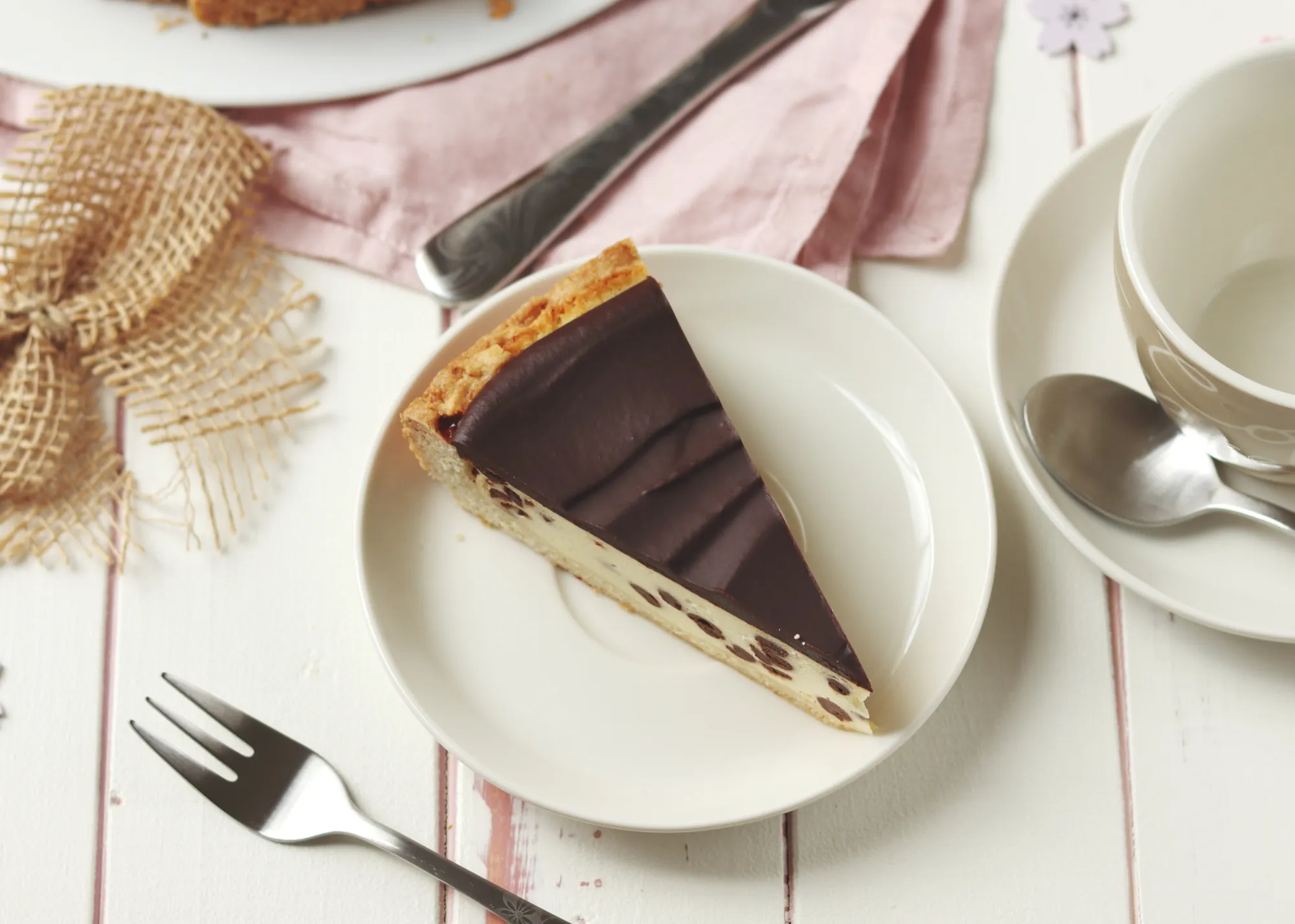 Detailaufnahme eines angeschnittenen Käsekuchens mit Schokolade, der die perfekte Verteilung der Schokodrops zeigt.