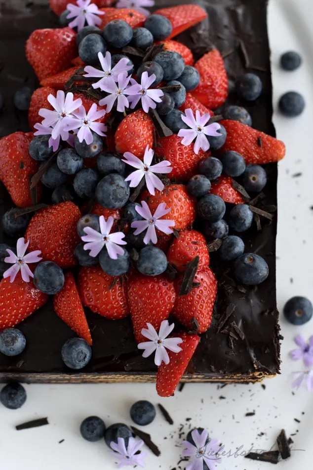 Detailaufnahme von frischen Beeren, die auf einem Kuchen arrangiert werden