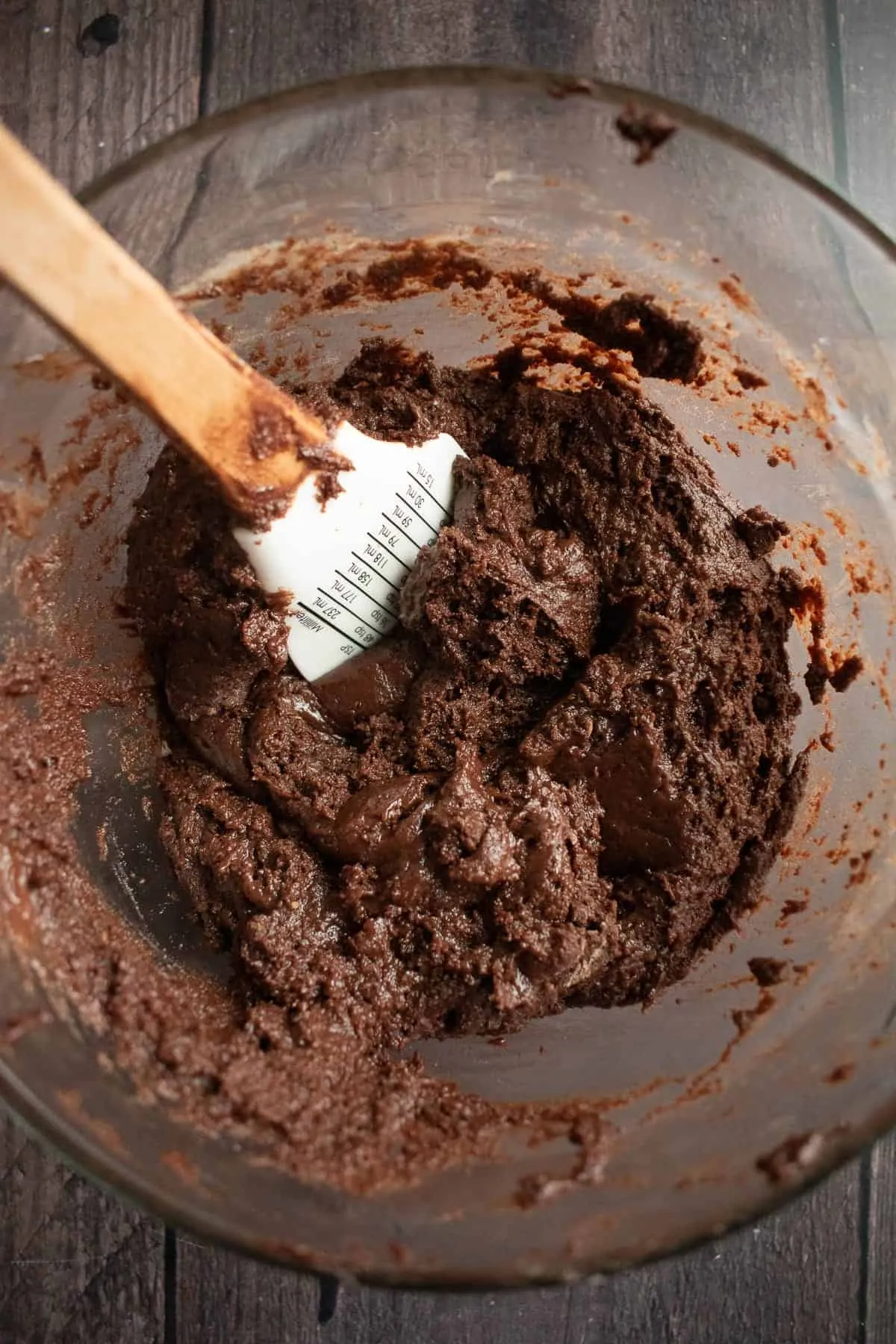 Dicker Schokoladenkuchenteig in einer Rührschüssel mit einem Silikonspatel.