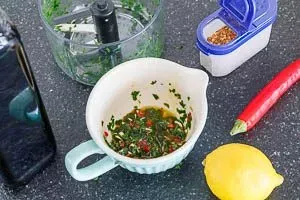 Die aromatische Olivenöl-Mischung mit Knoblauch, Chili, Zitrone und frischer Petersilie in einer Schüssel vorbereiten, die das Herzstück vieler einfacher deutscher und mediterraner Gerichte bildet.