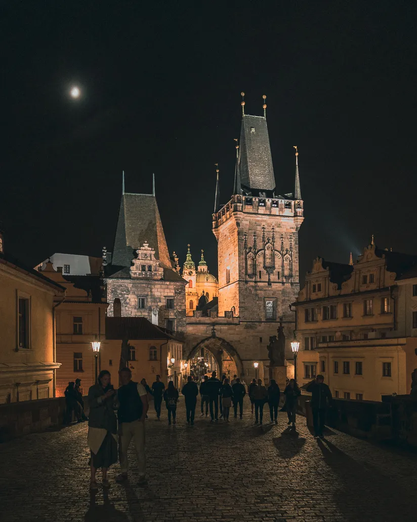 Die beleuchtete Karlsbrücke in Prag bei Nacht, ein magisches Motiv für unvergessliche Urlaubsfotos im Mai.