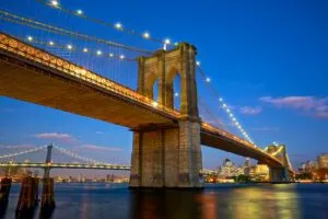 Die Brooklyn Bridge bei Sonnenuntergang, die Manhattan mit Brooklyn verbindet, ein ikonischer Punkt für New York City Reisetipps.