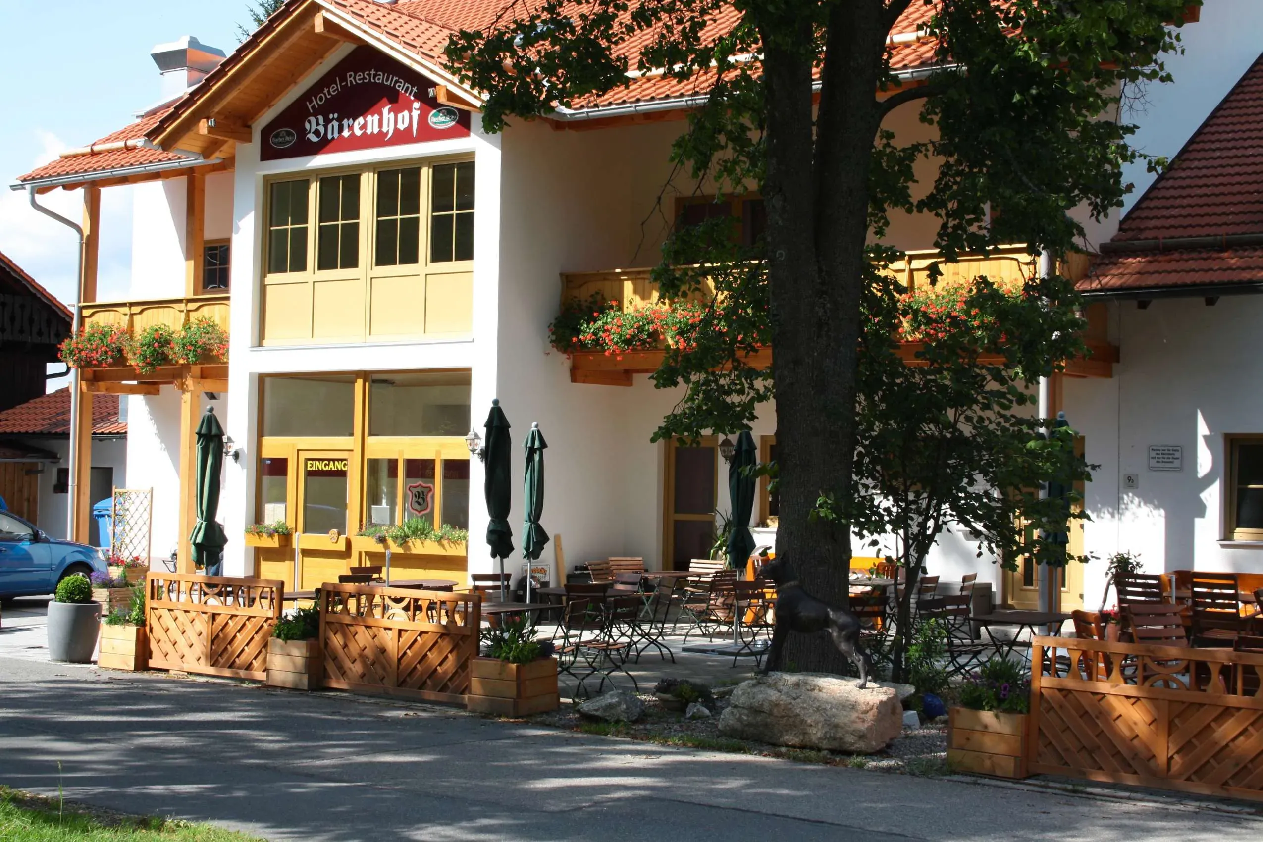 Die einladende Eingangstür und Terrasse des Hotel Bärenhof in Philippsreut, einem spezialisierten Hundehotel im Bayerischen Wald.