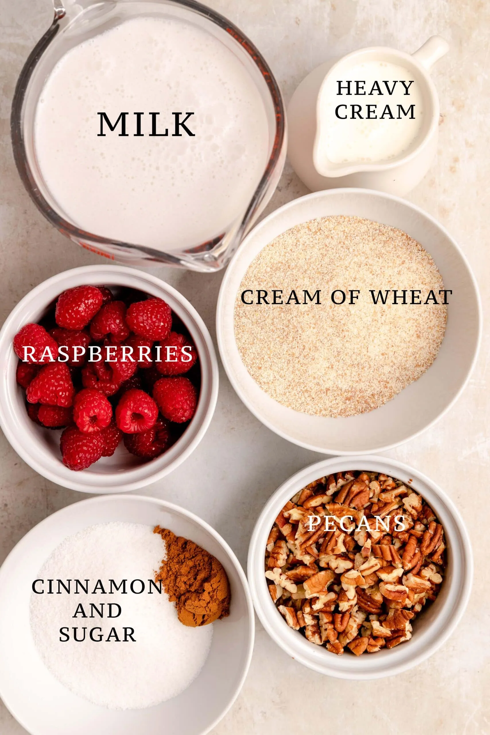Die Grundzutaten und verschiedene Beläge wie Zimtzucker, Beeren und Nüsse für die Zubereitung von Grießbrei.