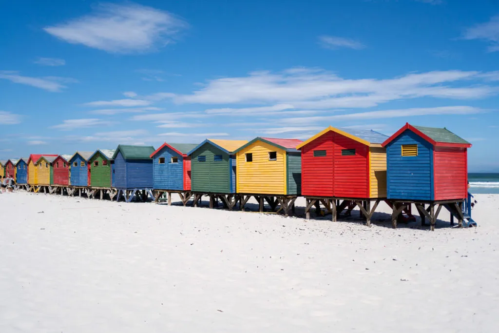 Die ikonischen bunten Strandhäuschen am Muizenberg Beach, einem Paradies für Surfer an der Garden Route
