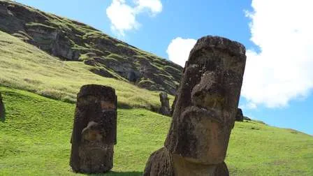Die Moai, mysteriöse kolossale Steinskulpturen, stehen auf der vulkanischen Osterinsel in Chile, umgeben von Graslandschaft.