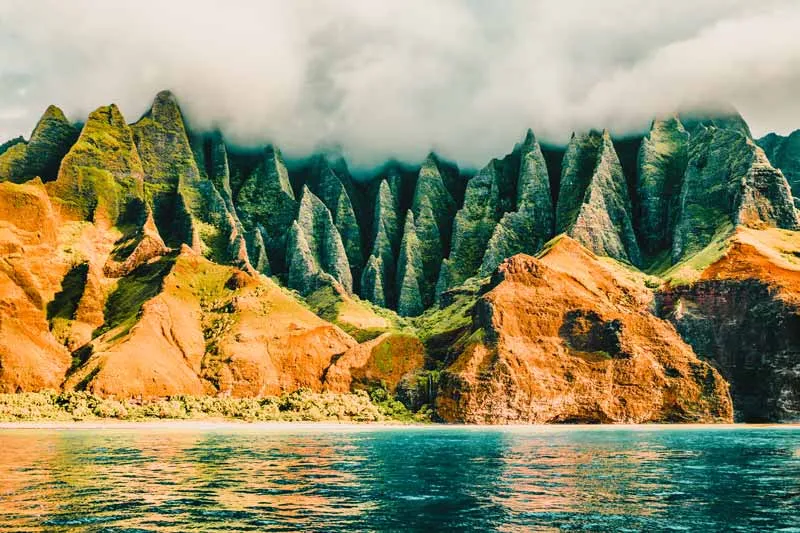 Die Na Pali Küste auf Kauai, Hawaii, mit ihrer dramatischen, zerklüfteten Landschaft – ein atemberaubender Reisetipp für Juli für Abenteurer.