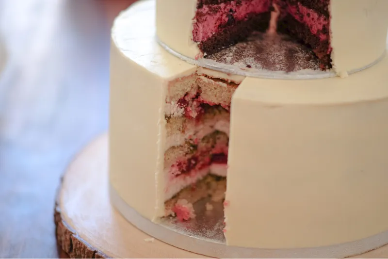 Die obere Torte wird angeschnitten, während die untere Torte noch gestapelt ist