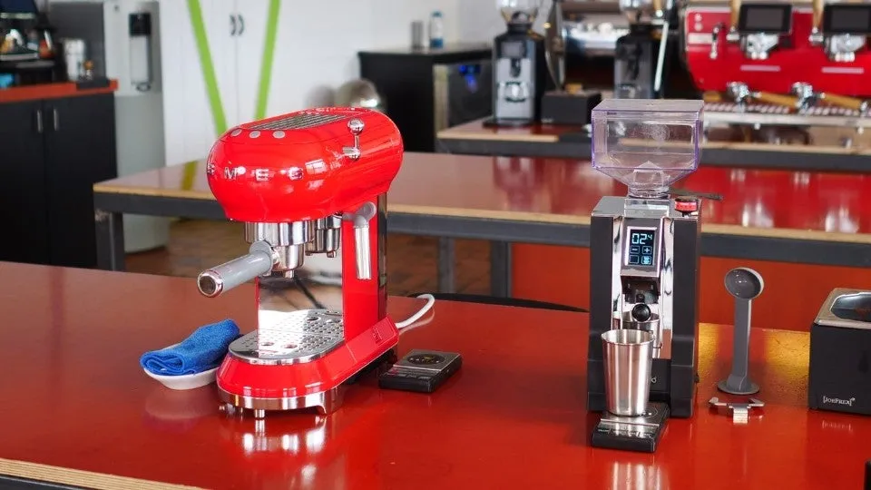 Die Smeg ECF01 Siebträgermaschine zusammen mit einer Eureka Perfetto Espressomühle, ein ideales Duo für Kaffeeliebhaber.