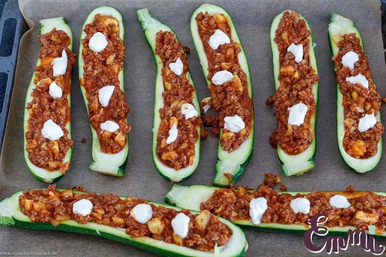Die vorbereiteten Zucchinihälften sind mit der würzigen Hackfleischfüllung bereit zum Überbacken