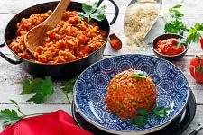 Djuvec Reis mit frischen Erbsen und Petersilie garniert in einer Pfanne