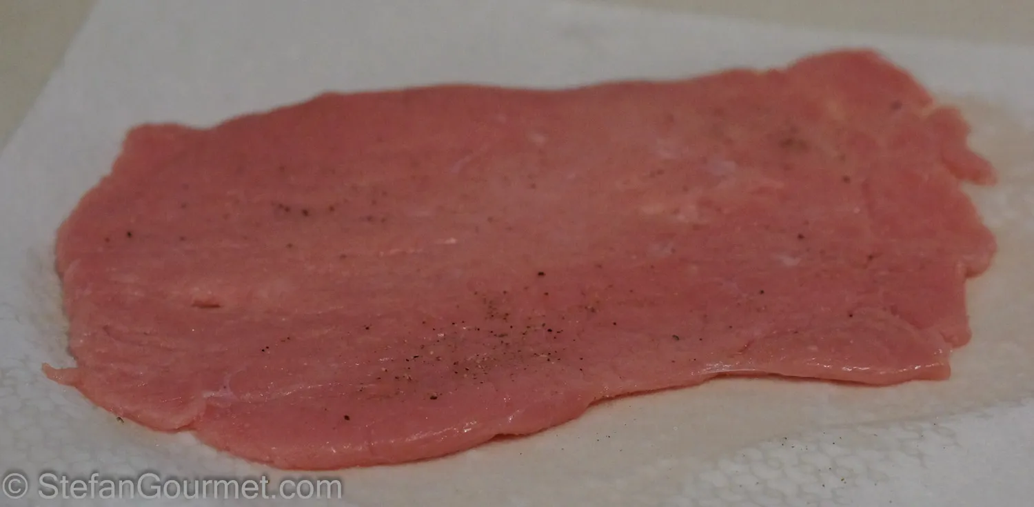 Dünn geklopftes Kalbs- oder Schweinefleisch mit Salz und Pfeffer gewürzt
