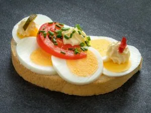 Ei-Scheiben und Tomate auf einem belegten Brötchen