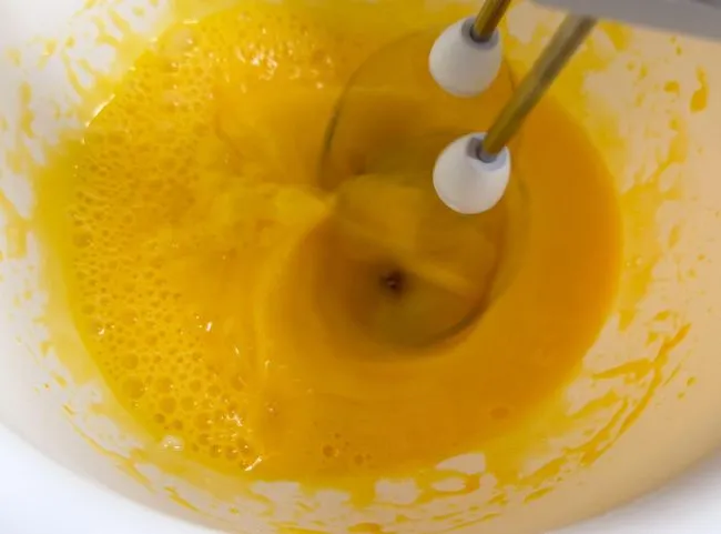 Ei und Rapsöl schaumig gerührt für den Teig des ersten Geburtstagskuchens ohne Zucker.