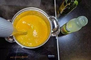 Eierlikörmasse über einem Wasserbad mit Cognac und Sahne rühren.