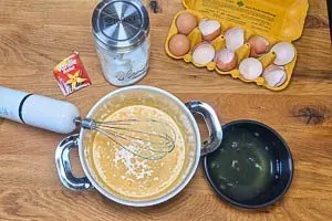 Eigelb und Zucker werden in einem Topf hellgelb und schaumig geschlagen.
