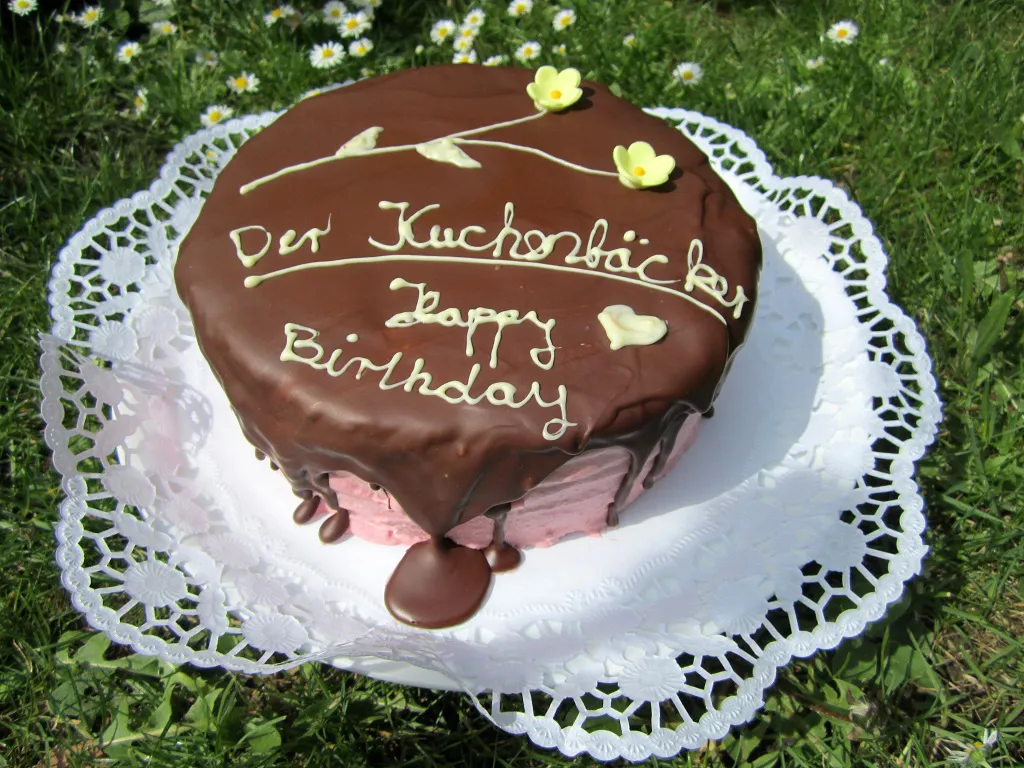 Ein angeschnittener Geburtstagskuchen 47 mit Schokoladenbrownie-Schichten und Himbeer-Meringue-Creme