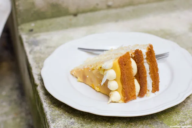 Ein angeschnittenes Stück der Ananas-Geburtstagstorte mit Ananas-Curd und Kokoscreme, ideal für den 11. Geburtstag