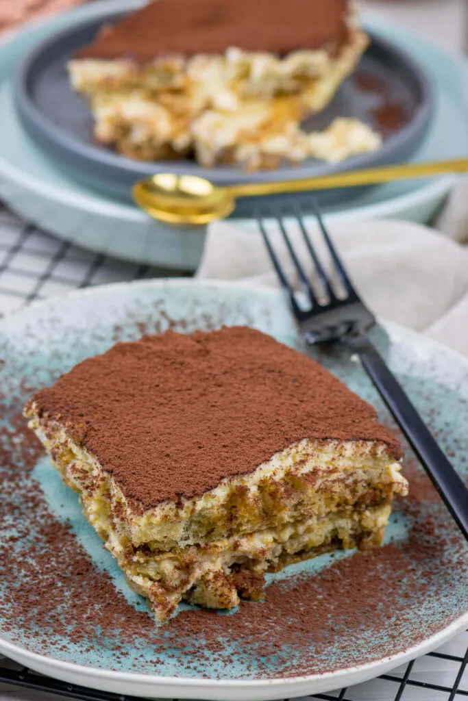 Ein appetitlich angerichtetes Tiramisu ohne Alkohol in einer Glasform, bestreut mit Kakaopulver, welches mit Bittermandelaroma zubereitet wurde und für die ganze Familie geeignet ist.