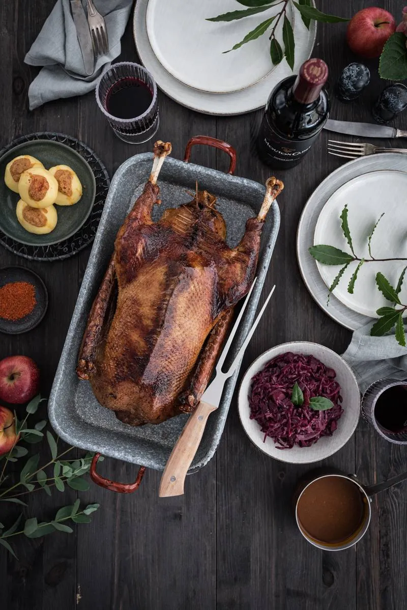 Ein appetitliches Foto eines ganzen Gänsebratens, der die knusprige Haut und die Füllung zeigt.