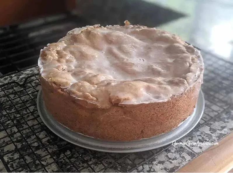 Ein aufgeschnittener Gedeckter Apfelkuchen, der die Schichten aus knusprigem Teig und saftiger Apfelfüllung zeigt, ein Genuss für jeden Liebhaber deutscher Backwaren.