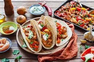 Ein Backblech voller frisch gebackener Chicken Fajitas, reichhaltig und aromatisch, bereit zum Servieren mit Tortillas