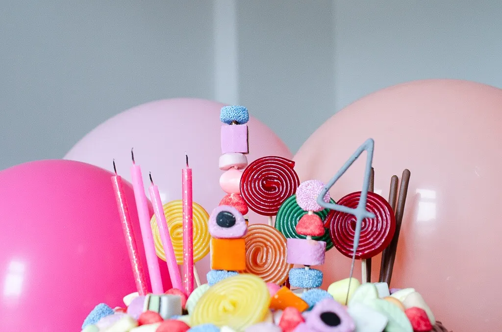 Ein beeindruckender Candy Cake, dekoriert mit einer Vielfalt an farbenfrohen Süßigkeiten und Kerzen, perfekt für Kindergeburtstage.