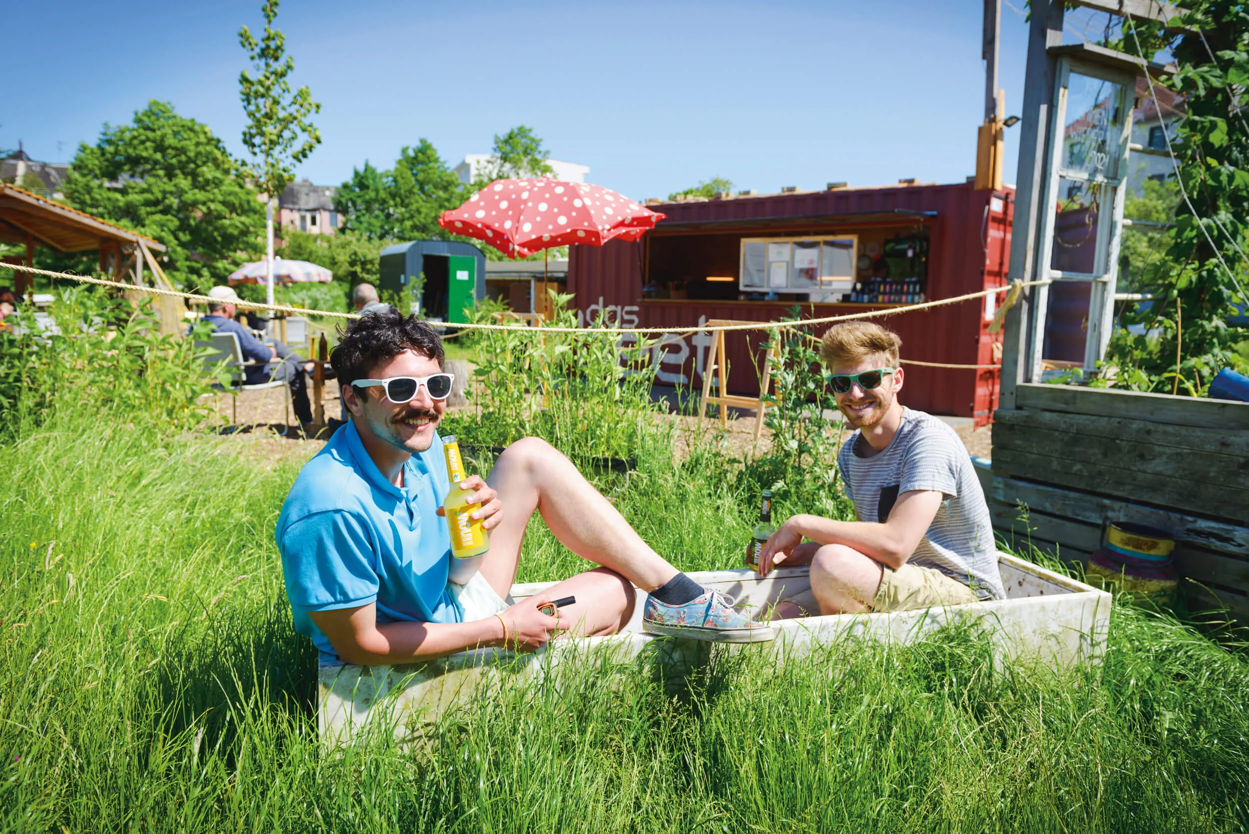 Ein Bild, das eine Grünfläche mit Sitzgelegenheiten zeigt