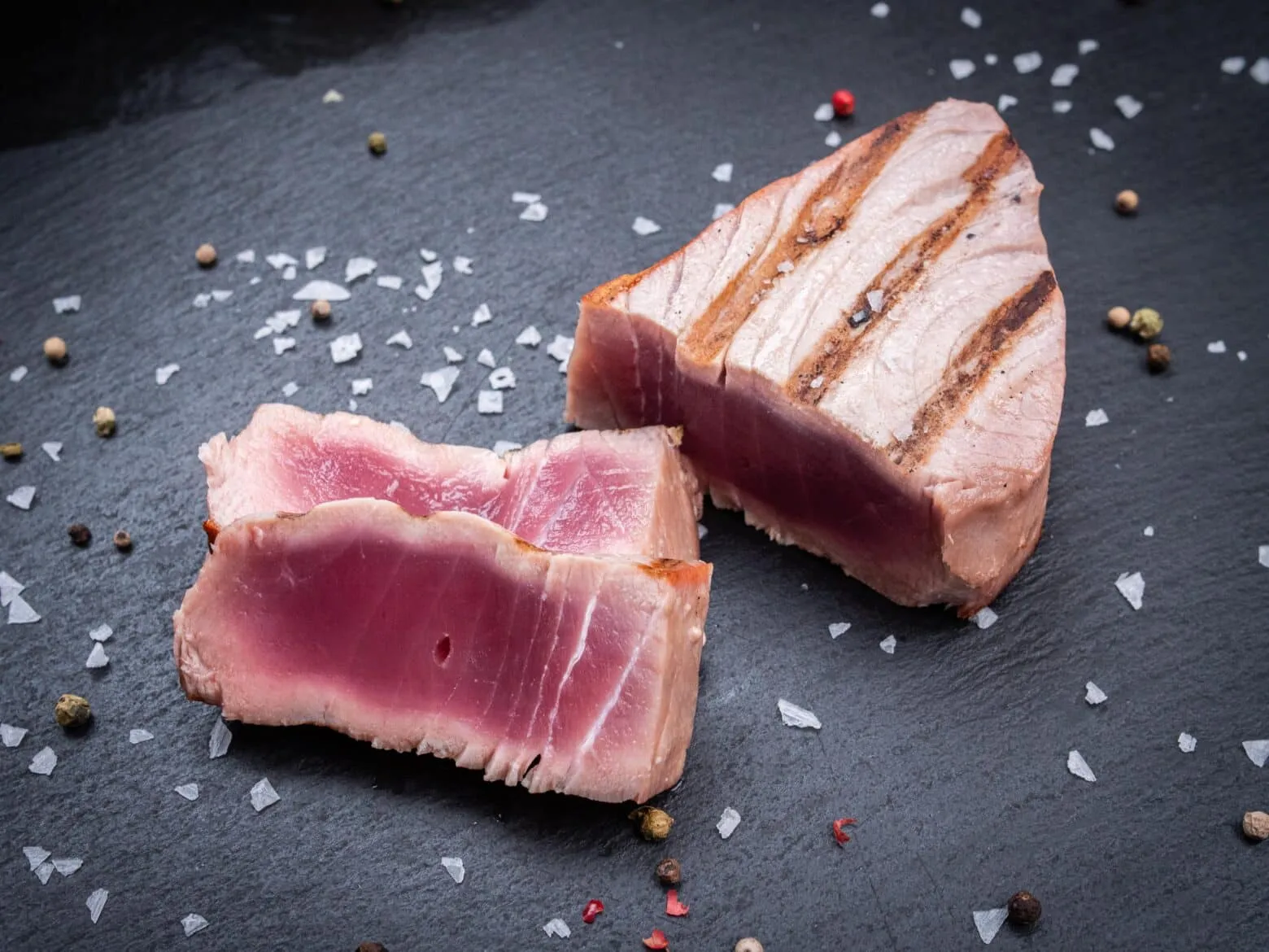 Ein dickes Thunfischsteak mit perfektem Grillmuster und rosa Kern, ein Highlight für jeden Grillabend.