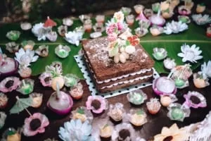 Ein eleganter hawaiianischer Baby-Geburtstagskuchen in Ombre-Blautönen, verziert mit tropischen Blumen, für eine sanfte Feier.