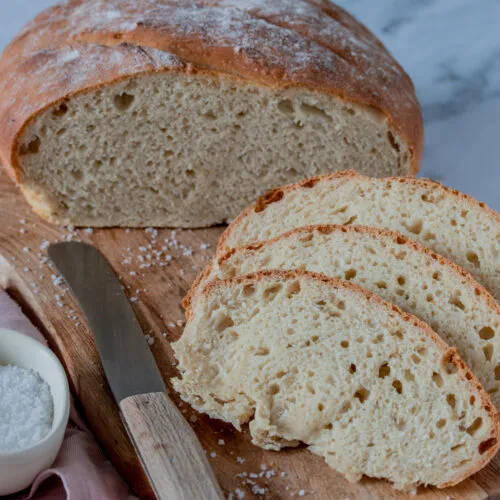 Ein fertig gebackener Brotlaib mit tiefen Einschnitten auf einem Backblech, bereit zum Abkühlen nach dem brot backen.