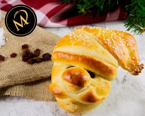 Ein festlich dekorierter Nikolaus aus süßem Hefeteig auf einem Backblech, bereit zum Genuss