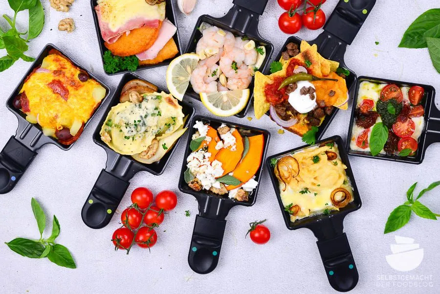 Ein festlich gedeckter Tisch mit einem Raclette-Grill, verschiedenen Käsesorten, Gemüse und Fleisch für ausgefallene Raclette Ideen.