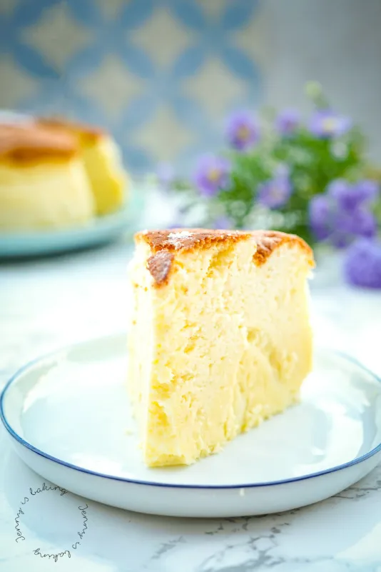 Ein fluffiger japanischer Käsekuchen, angeschnitten und auf einem Teller serviert, der seine leichte und cremige Textur zeigt.