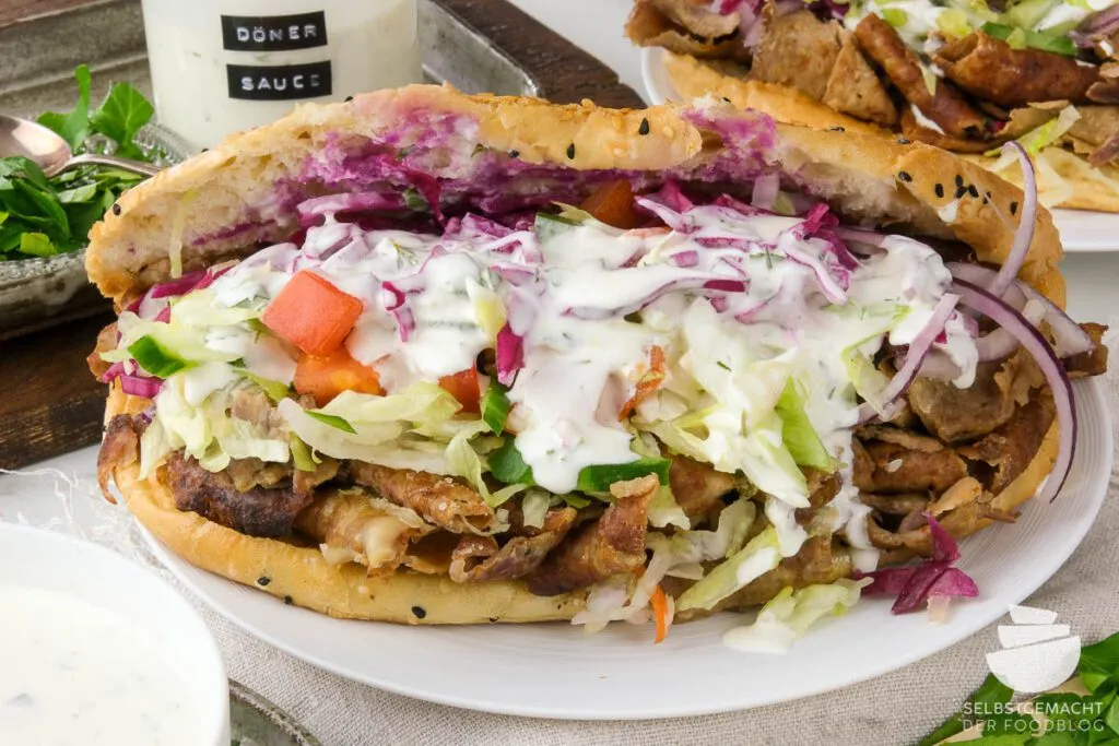 Ein frisch belegter Döner mit knackigem Salat und reichlich selbstgemachter cremiger Dönersoße.
