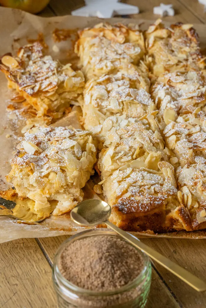 Ein frisch gebackener Apfelkuchen mit Marzipan, bestreut mit gehobelten Mandeln, der seine goldbraune Farbe und Saftigkeit zeigt