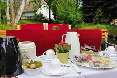 Ein gedeckter Tisch mit Frühstück auf einem Kahn im Spreewald, ideal für eine romantische oder genussvolle Frühstückskahnfahrt.
