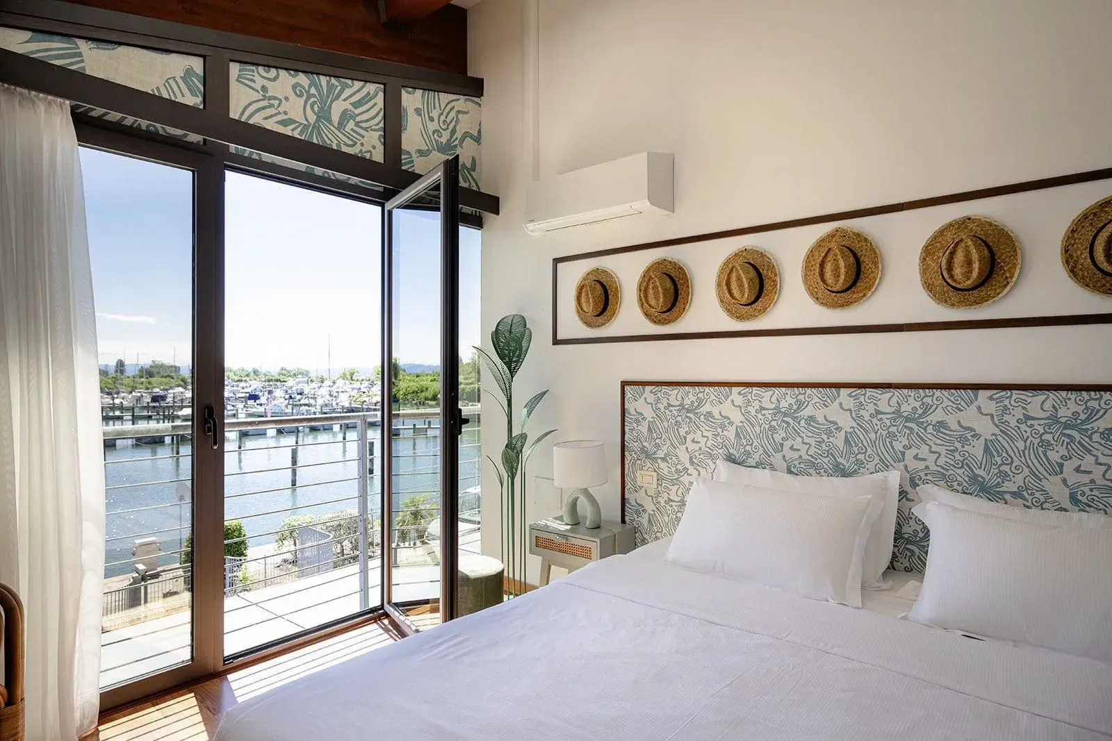 Ein gemütliches Schlafzimmer im Club del Sole Tenuta Primero Grado Family Collection, mit Blick auf den Yachthafen – ideal für einen entspannten Urlaub mit Hund in Italien.