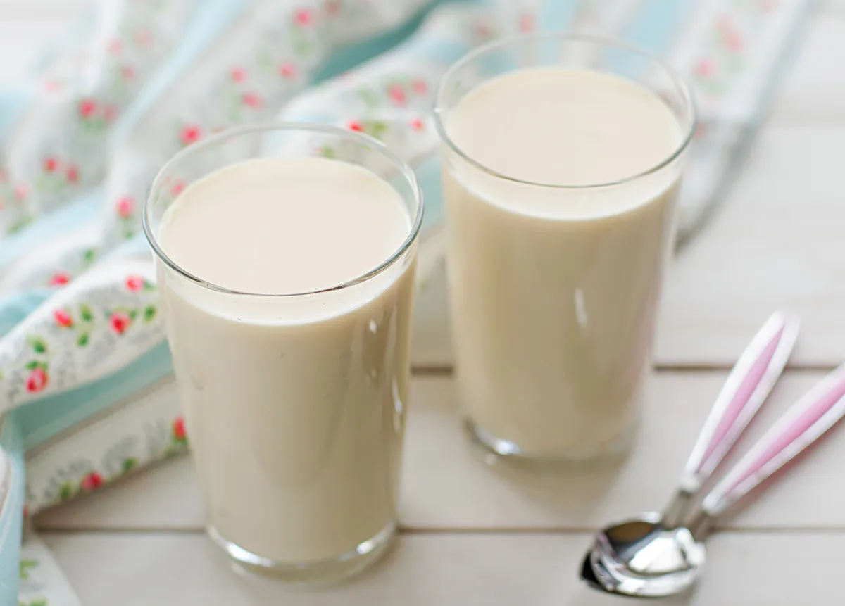 Ein Glas cremiger Rjaschenka, ein fermentiertes Milchgetränk mit einem einzigartigen Karamellgeschmack, hergestellt aus gebackener Milch.