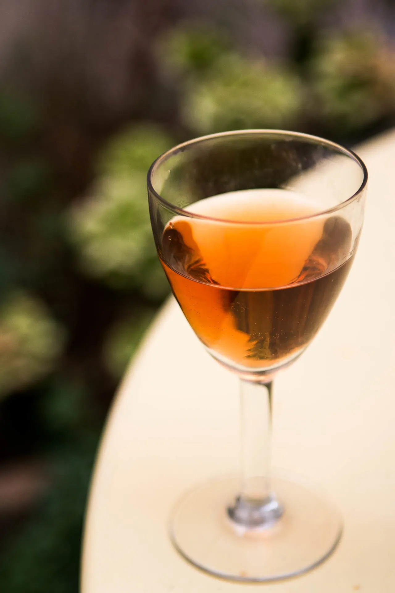 Ein Glas Kir Aperitif mit rotem Crème de Cassis und Weißwein, elegant serviert.