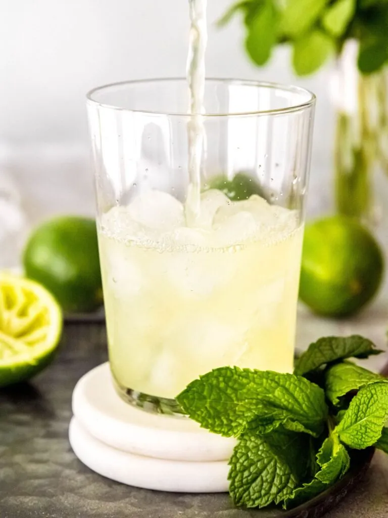 Ein Glas mit Eis wird mit der Cool Lime Refresher Basis aufgefüllt.