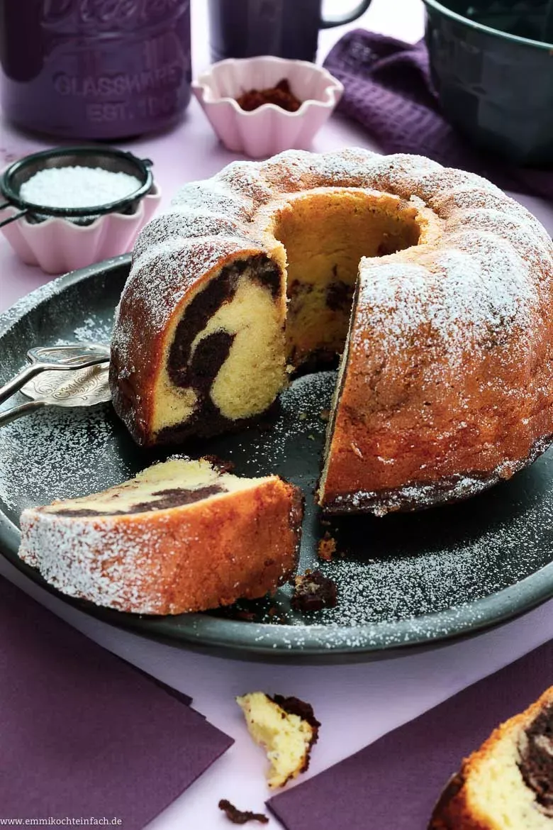 Ein goldbrauner Marmorkuchen aus Omas Rezept in einer Gugelhupfform, bereit zum Servieren auf einer traditionellen deutschen Kaffeetafel