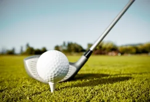 Ein Golfball liegt bereit für den Abschlag auf einem idyllischen Golfplatz in Norddeutschland.