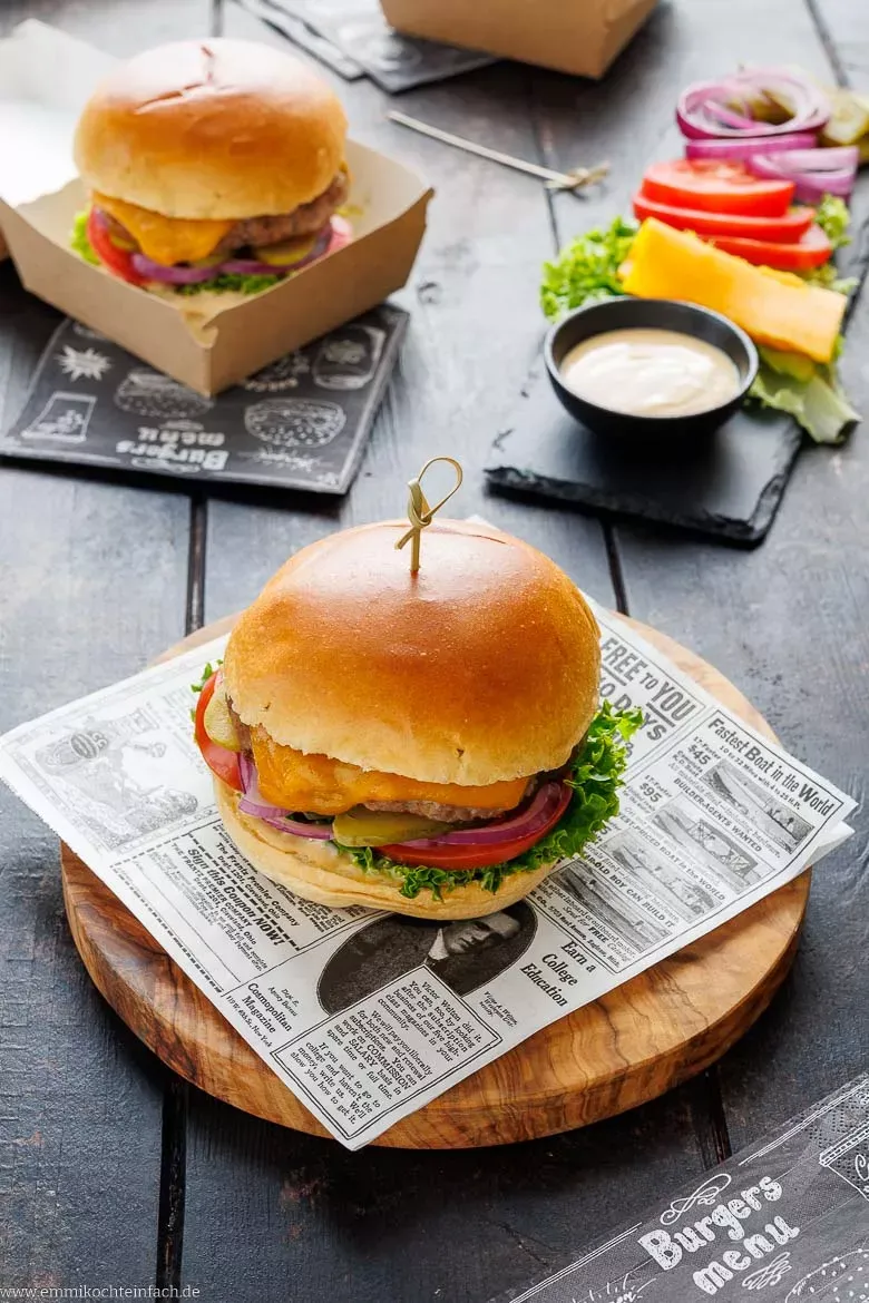Ein hausgemachter Hamburger, perfekt geschichtet mit einem Rindfleischpatty, schmelzendem Käse, frischem Salat und Tomate, bereit zum Genuss.