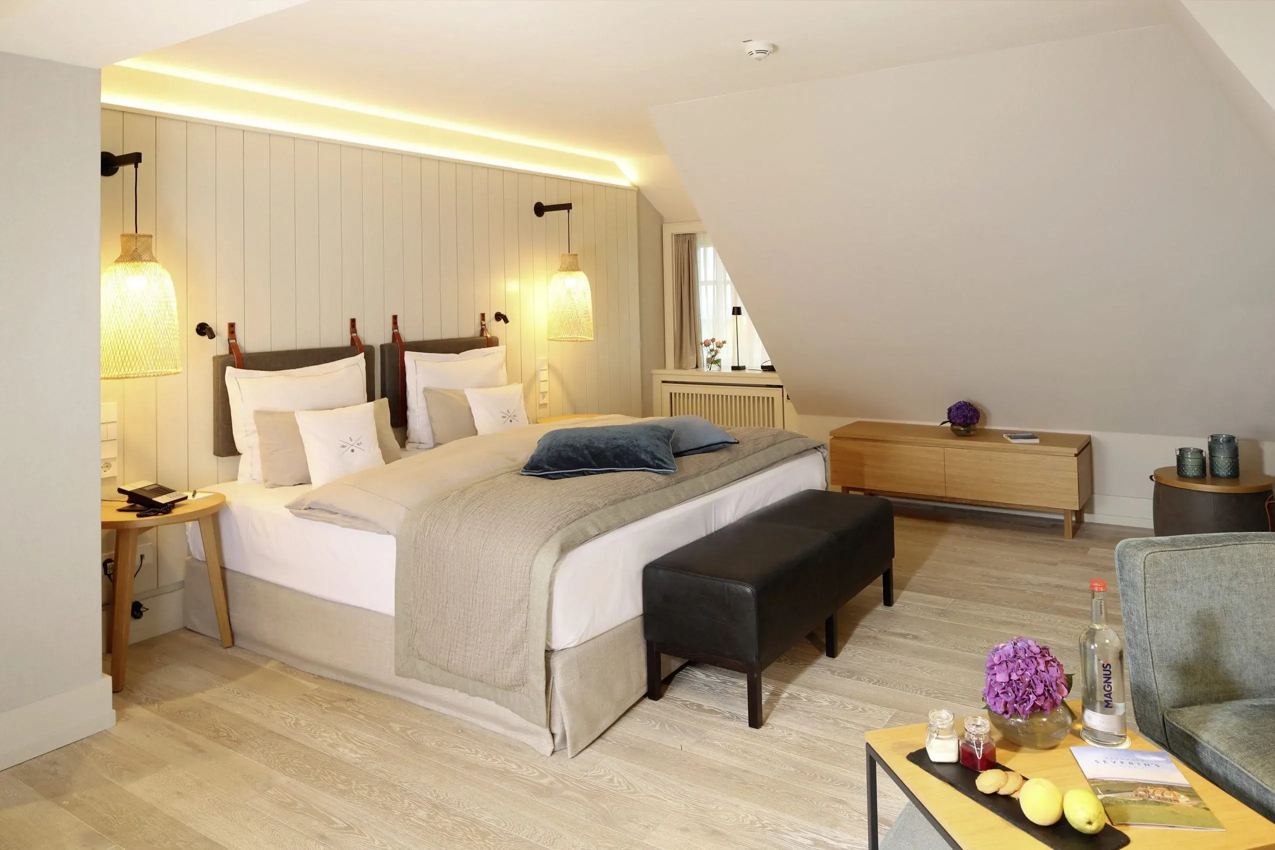 Ein helles und gemütliches Doppelzimmer im Landhaus Severin's Morsum Kliff, das eine warme Atmosphäre für Gäste und ihren Hund schafft.