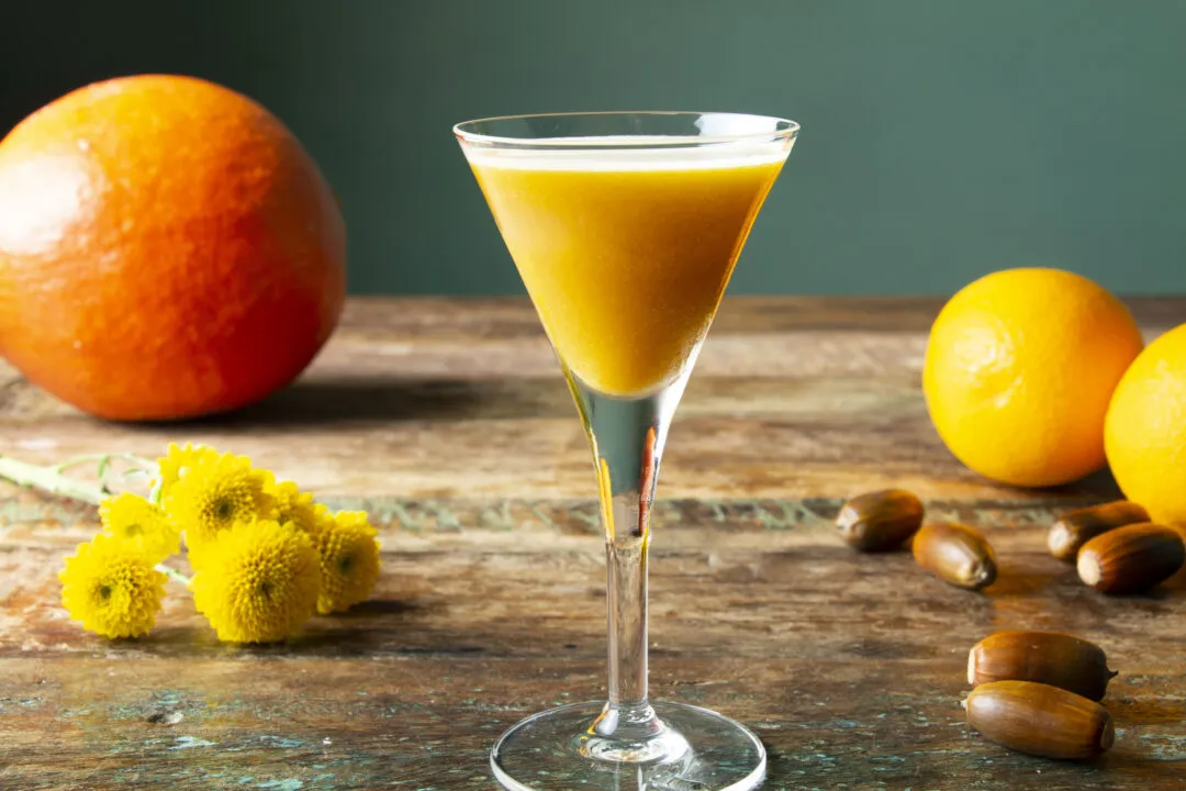 Ein herbstlicher Cocktail mit Kürbis, Orangen, Kastanien und gelben Blumen