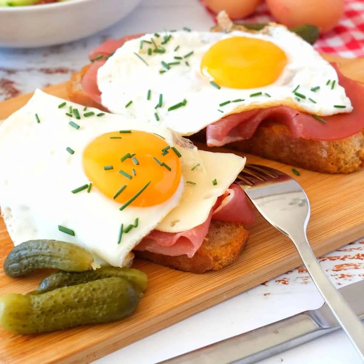 Ein herzhafter Strammer Max, frisch zubereitet mit knusprigem Roggenbrot, geräuchertem Schinken und einem perfekt gebratenen Spiegelei mit flüssigem Eigelb, garniert mit frischem Schnittlauch. Ideal für eine deftige Brotzeit oder als schnelles Abendessen.