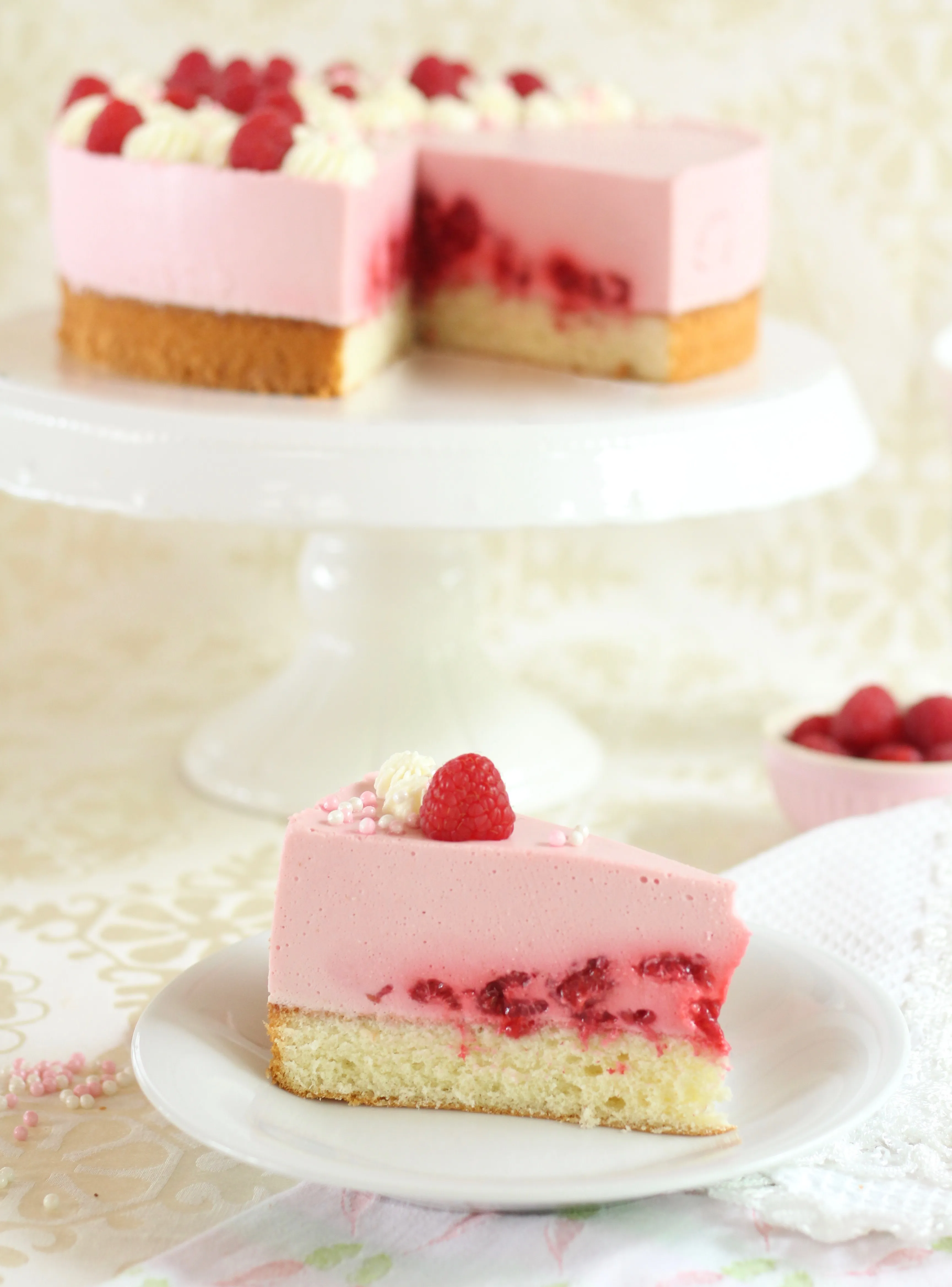 Ein hoher Anschnitt einer Himbeersahne-Torte, die eine luftige Struktur zeigt