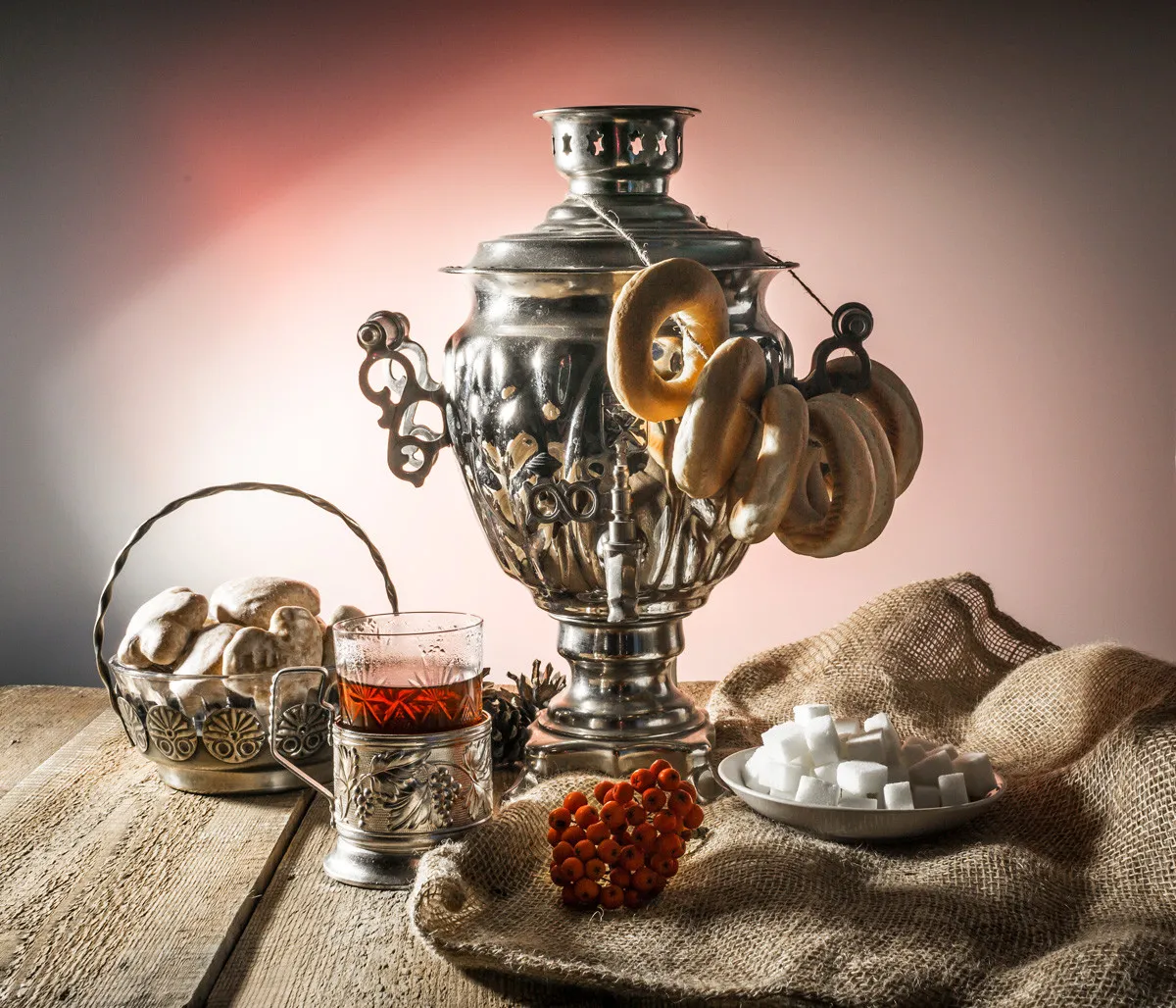 Ein klassischer russischer Samowar, der kochendes Wasser für Tee bereitstellt, umgeben von traditionellen Teegläsern mit Zitronenscheiben.
