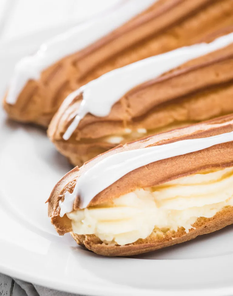 Ein klassisches Vanille-Eclair mit glänzendem Fondantüberzug bereit zum Kauf in der Bäckerei